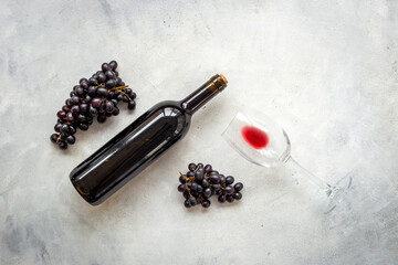 Obraz premium Red wine in the bottle with bunch of grapes and glass, top view