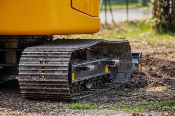 Large excavator steel tracks side view on rough terrain in construction project