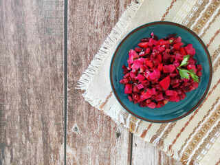 Delicious vegetarian salad vinaigrette of boiled beetroot and various vegetables on a blue plate
