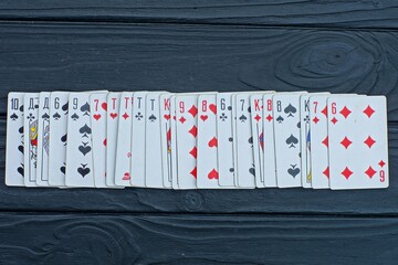 paper white playing deck of cards lies on a black wooden table