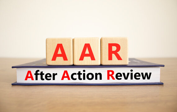 AAR After action review symbol. Concept words AAR After action review on beautiful wooden blocks and book. Beautiful white background. Business AAR after action review concept. Copy space.