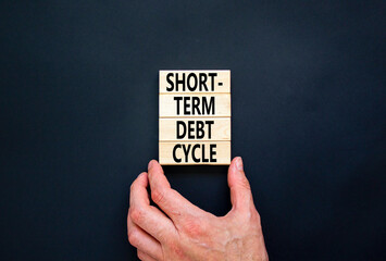 Short-term debt cycle symbol. Concept words Short-term debt cycle on beautiful wooden block. Beautiful black table background. Businessman hand. Business Short-term debt cycle concept. Copy space.