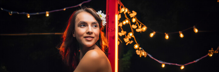 woman portrait at a party with red structure and golden lights