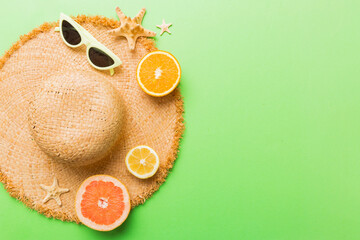 Top view of various seashells placed near colorful fruit and stylish summer accessories on table...