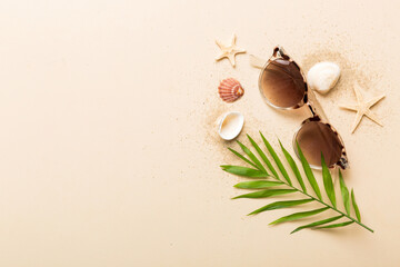 Fototapeta na wymiar sunglasses with seashell lying on table background. Sunglasses on summer background. Top view flat lay with copy space for text