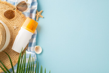 Overhead view of SPF lotion amidst beach accessories on a pastel blue background. Sun protection essentials for radiant skin. Perfect for promoting skincare and UV protection products
