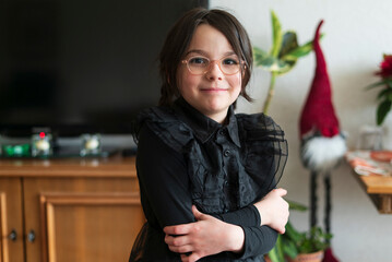 Portrait of a cute little girl in a black dress and glasses