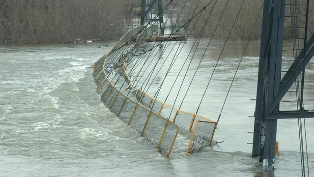 old metal bridge under flood water from river during floods. Medium shot collapsed bridge sitting in flooded river. flooding bridge. The river that flooded the city