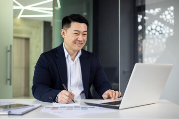 Professional Asian businessman working happily in modern office