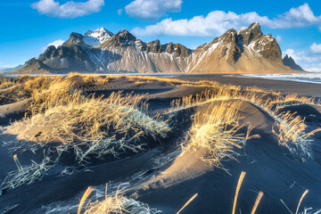 Mountains and volcanic lava sand dunes by the sea in Stokksness, Iceland.