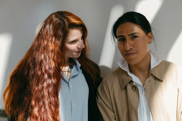 Modern couple in light and shadow: ecuadorian man and redhead woman at museum.