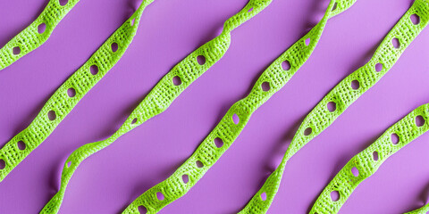 Close up view of green and purple ribbons with words ribbons and ribbon on purple background