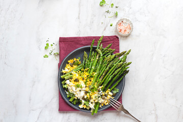 Asparagus salad Mimosa. Spring and Easter salad with grated egg, capers and aromatic dressing. Sunlight background. Healthy vegetarian balanced recipes for spring, seasonal cuisine