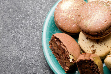 Macaroons with chocolate cream on a dark background.