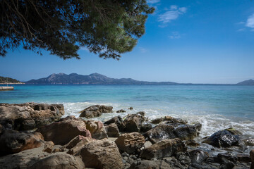 Playa de Formentor, Mallorca, Balearic Islands, Spain. Beautiful rocky beach, turquoise Mediterranean sea, blue sky, no people.