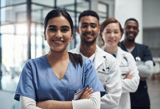 Fototapeta Doctors, woman and arms crossed with smile, team or portrait for diversity in medical career at hospital. Surgeon group, people and men with collaboration, wellness and pride for healthcare services