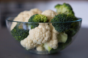 fresh broccoli and cauliflower in a bowl and on the table