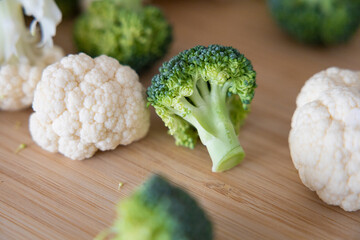 fresh broccoli and cauliflower in a bowl and on the table
