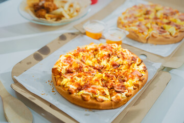 Savor a delicious slice of Italian pizza, baked to perfection with mozzarella, ham, pineapple, and pepperoni. Enjoy it at a rustic restaurant or homemade at your kitchen table.