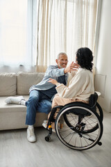 Fototapeta na wymiar A man and a disabled woman hugging each other affectionately in a cozy living room.