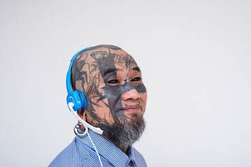 An Asian call center agent covered in face tattoos and piercings, wearing a headset, against a white background. Diversity in BPO workforce.