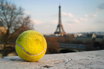 tennis ball on parisian surface with scenic eiffel tower in distance, olympic games concept - obrazy, fototapety, plakaty
