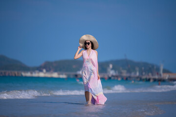 Happy sexy Asian traveller woman wear colorful beach dress and hat show enjoys on tropical beach vacation in summer holidays	 - 796759162