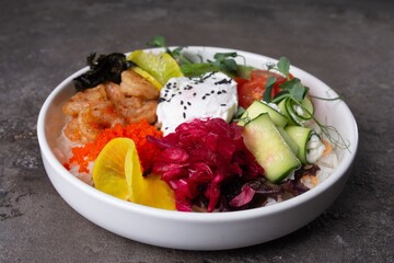 Scrumptious seafood rice bowl with fresh vegetables and egg on a dark background