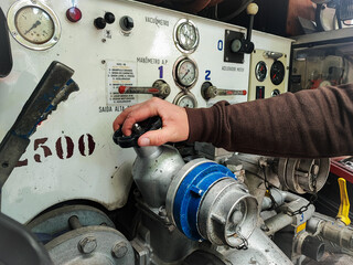 Close-up of a man's hand with fire equipment in a fire truck. Man turns control levers