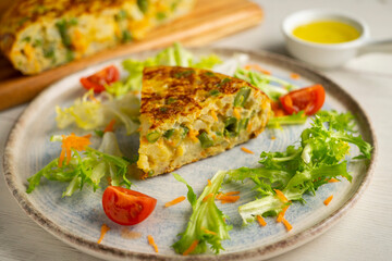Spanish potato omelet with cauliflower and vegetables. Traditional Spanish tapa recipe.