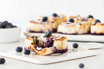 Homemade blueberry cinnamon roll with other rolls in behind.