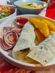 Beef and lamb doner kebab wraps with flatbread and vegetables on a white plate