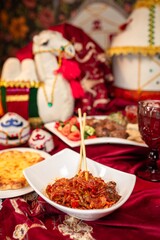 Delectable Noodles with Meat and Vegetables on a Red Tablecloth
