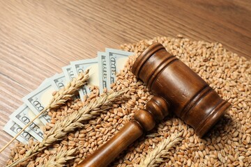 Agricultural business. Dollar banknotes, judge's gavel, wheat ears and grains on wooden table, closeup. Space for text
