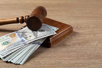 Judge's gavel and money on wooden table