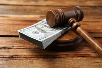 Judge's gavel and money on wooden table, closeup