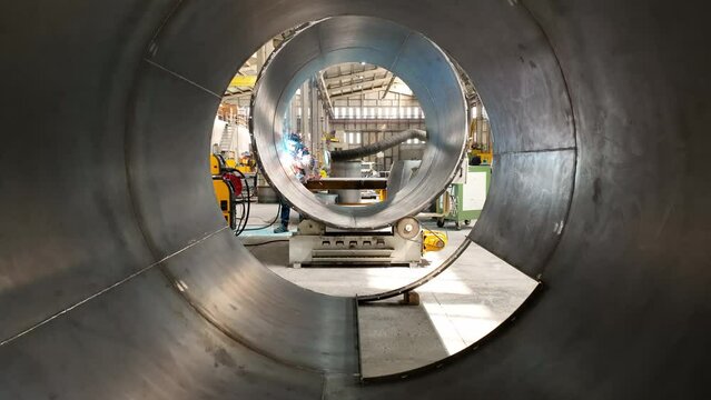 A worker welding in factory. Cinematic view of heavy industry.