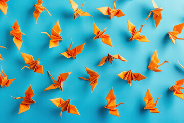 Beautiful flock of orange origami birds soaring in the sky on a peaceful blue background