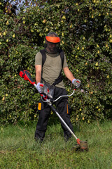 Man trimming grass with a weed whacker