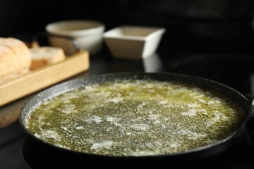 Melted butter in frying pan on table, closeup