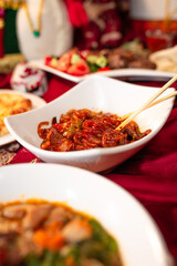 Delectable Noodles with Meat and Vegetables on a Red Tablecloth
