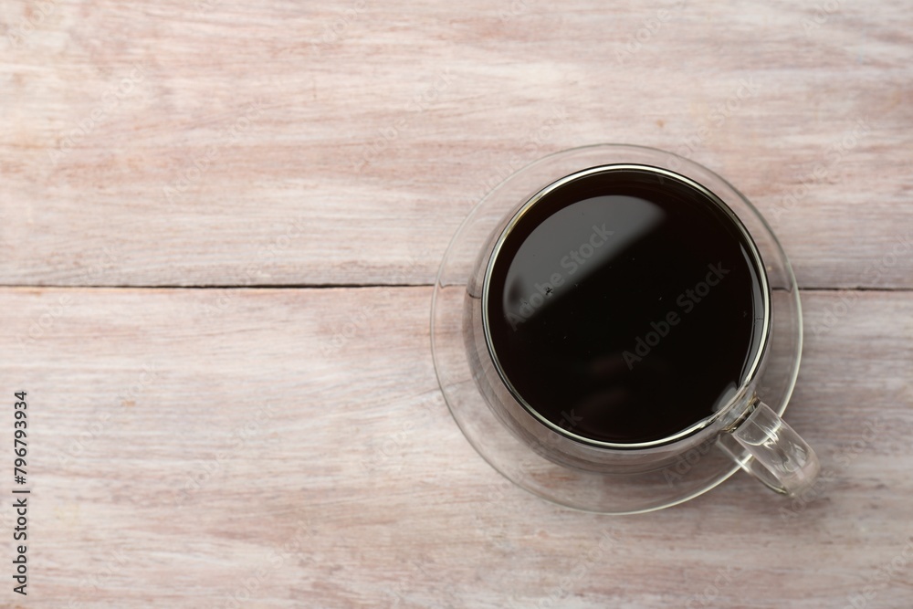 Wall mural Hot coffee in cup on wooden table, top view. Space for text