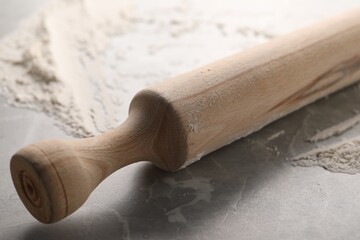 Rolling pin and flour on grey marble table, closeup
