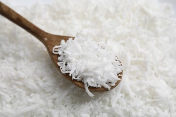 Fresh coconut flakes and wooden spoon, closeup