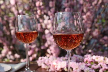 Glasses of rose wine on table in spring garden