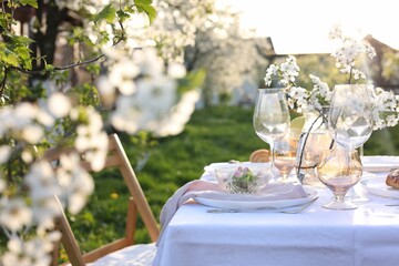 Stylish table setting with beautiful spring flowers in garden