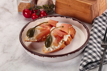 Bruschetta with jamon and caper berries