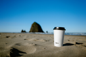 Coffee cup with name on Cannon Beach by Haysack Rock.