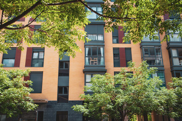 Residential neighborhood with modern architecture. Tall high-rise buildings with many apartments, windows and balconies facade view. House among green leaves Real estate in Madrid, Spain Rent buy flat