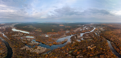 Aerial Siverskyi Donets river valley vibrant autumn panorama with wooded riverbanks and scenic sky in Ukraine